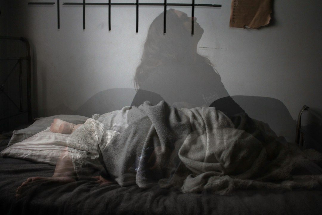 Adult resting in bed at night, illustrating sleep disturbance and bedtime routines